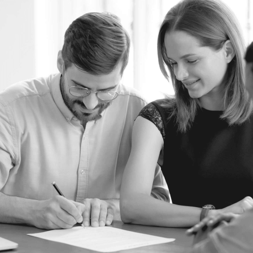 A couple signing a document for a real estate transaction